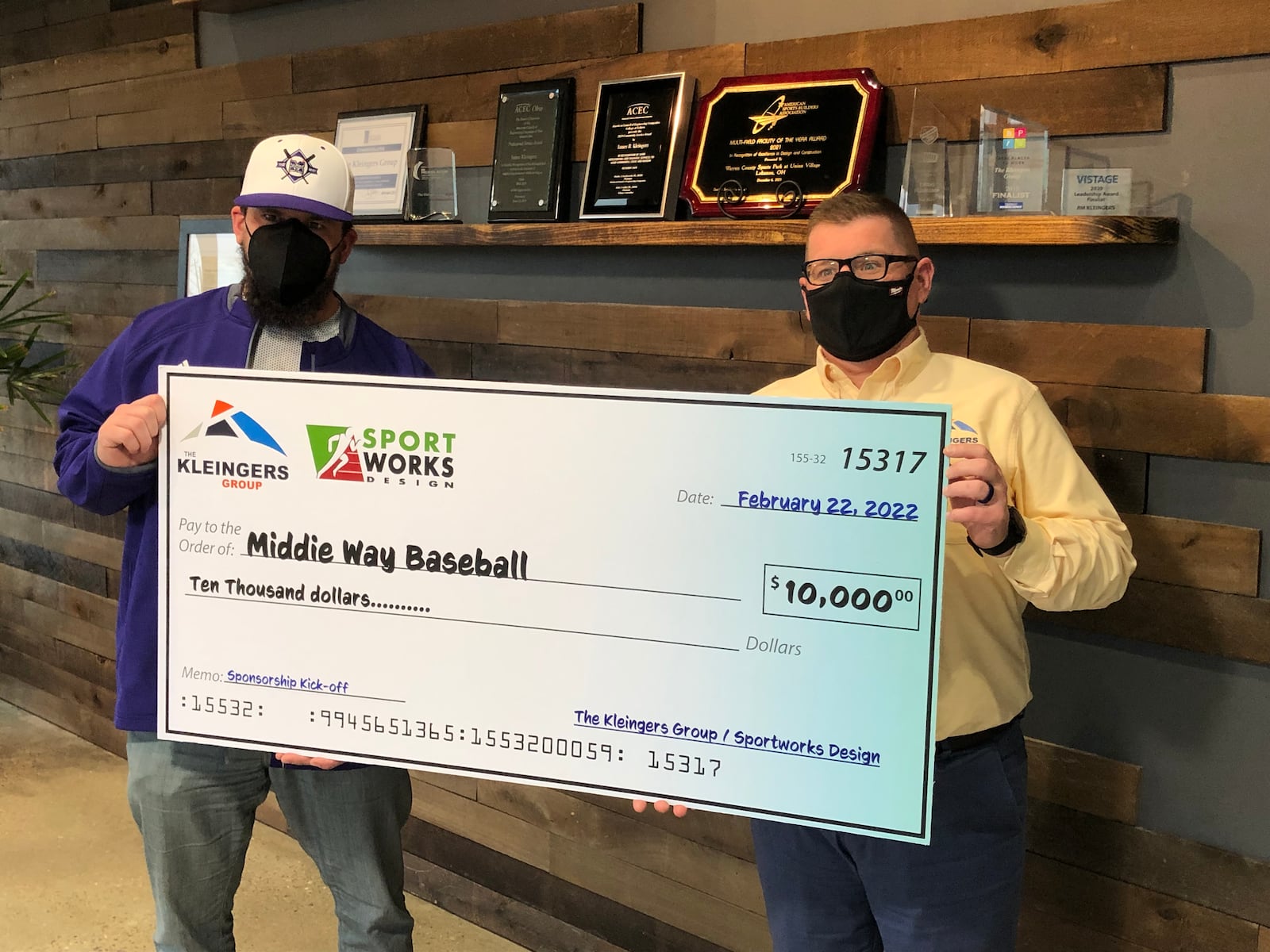 Tim Casto, right, president and CEO of The Kleim Group,, presents a $10,000 check to Kyle Schwarber, a Mddletown High School graduate and MLB player, Tuesday afternoon. The money will be used to purchase equipment for Middie Way Baseball. RICK McCRABB/STAFF