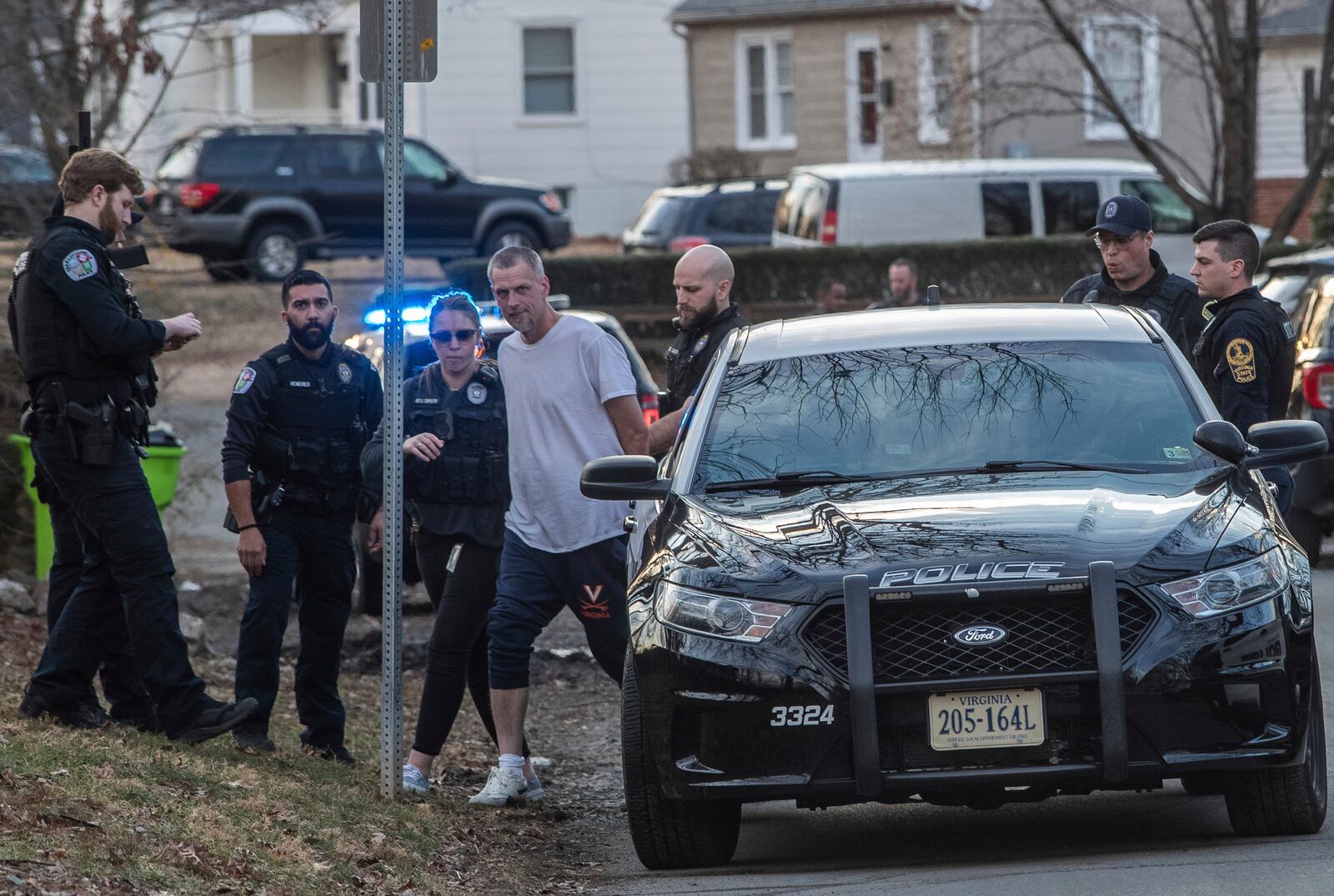 Charlottesville police lead the man suspected of a knife attack on University of Virginia Grounds to a police car, Thursday, Feb. 27, 2025, on Stribling Avenue on the border of the city's Jefferson Park Avenue and Fifeville neighborhoods. (Cal Cary/The Daily Progress via AP)