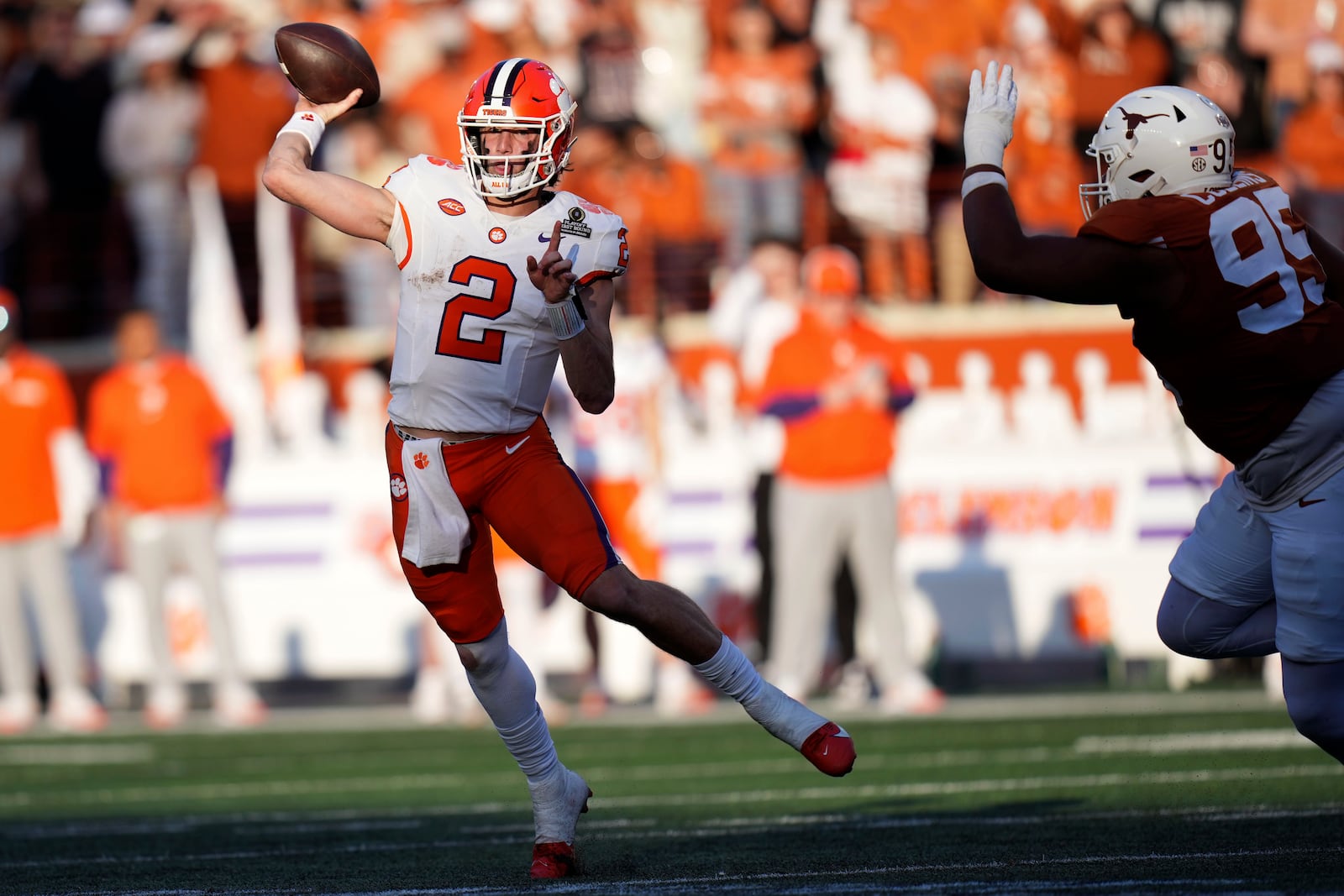 Clemson quarterback Cade Klubnik (2) throws a pass as he is pressured by Texas defensive lineman Alfred Collins (95) during the first half in the first round of the College Football Playoff, Saturday, Dec. 21, 2024, in Austin, Texas. (AP Photo/Eric Gay)