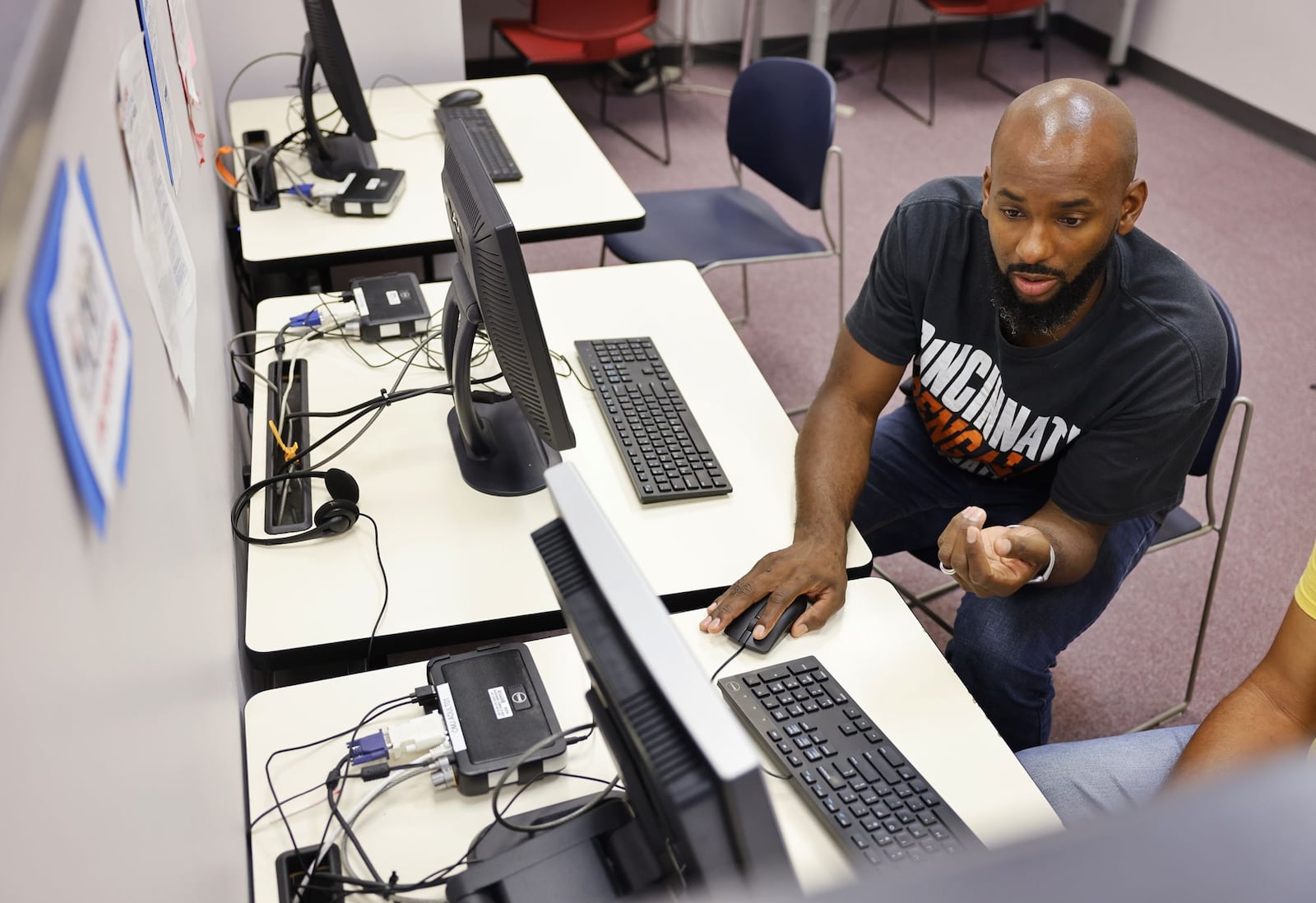 In this file photo, career advisor Marques Ingram helps a client get started on a computer in the resource room at Ohio Means Jobs in Fairfield. NICK GRAHAM/STAFF