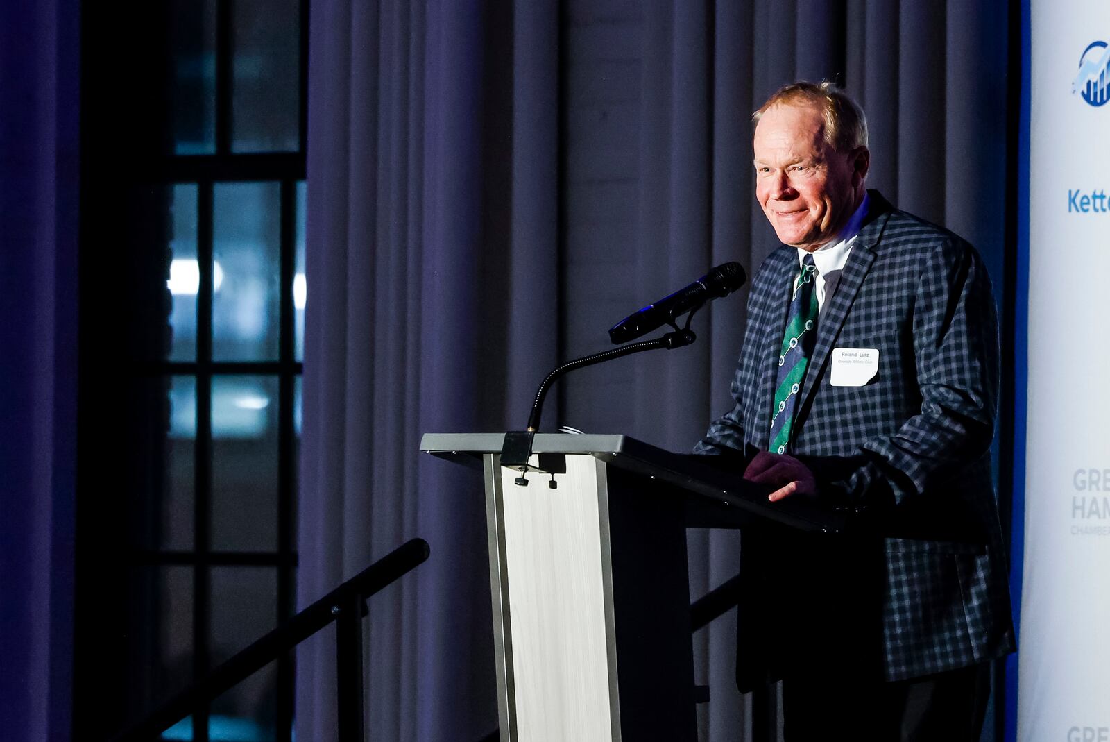 Small Business Person of the Year Roland Lutz, owner of Riverside Athletic Club, speaks as hundreds gather for the annual Greater Hamilton Chamber of Commerce dinner Friday, Jan. 26, 2024 at Spooky Nook Sports Champion Mill in Hamilton. Taylor Stone-Welch was honored as Hamilton Citizen of the Year and Roland Lutz was honored as Small Business Person of the Year. NICK GRAHAM/STAFF