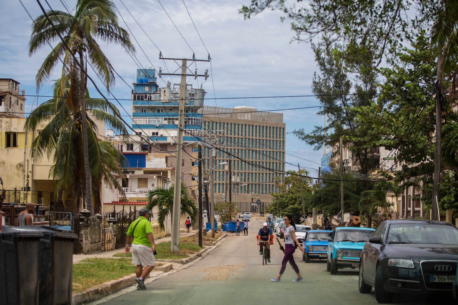 FILE - Pedestrians walk on a street that leads to the United States Embassy, center in background, in Havana, Cuba, Sept. 27, 2017. (AP Photo/Desmond Boylan, File)