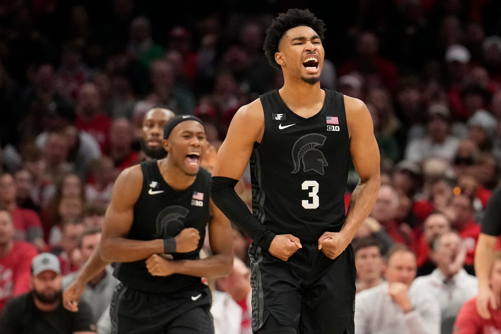 Michigan State guard Tre Holloman, left, and guard Jaden Akins (3) celebrate in the second half of an NCAA college basketball game against Ohio State Friday, Jan. 3, 2025, in Columbus, Ohio. (AP Photo/Sue Ogrocki)