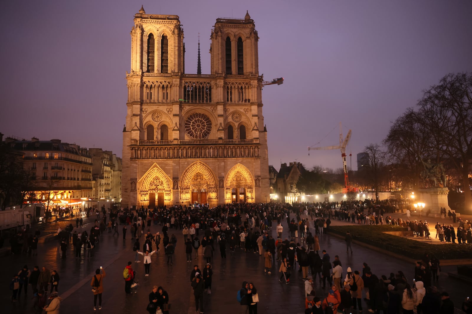 People queue to attend the mass at Notre Dame Cathedral as the monuments hosts Christmas Eve services for the first time since a devastating 2019 fire, Tuesday, Dec. 24, 2024 in Paris. (AP Photo/Thomas Padilla)