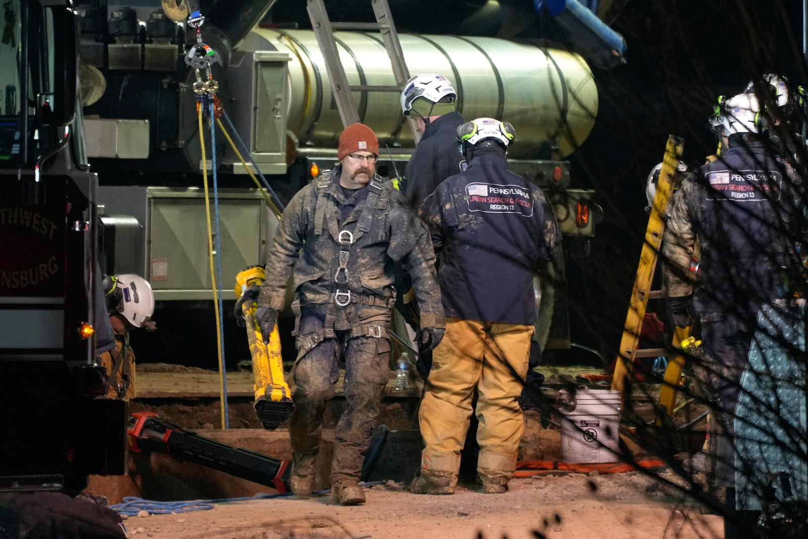 Rescue workers search through the night in a sinkhole for Elizabeth Pollard, who disappeared while looking for her cat, in Marguerite, Pa., Tuesday, Dec. 3, 2024. (AP Photo/Gene J. Puskar)