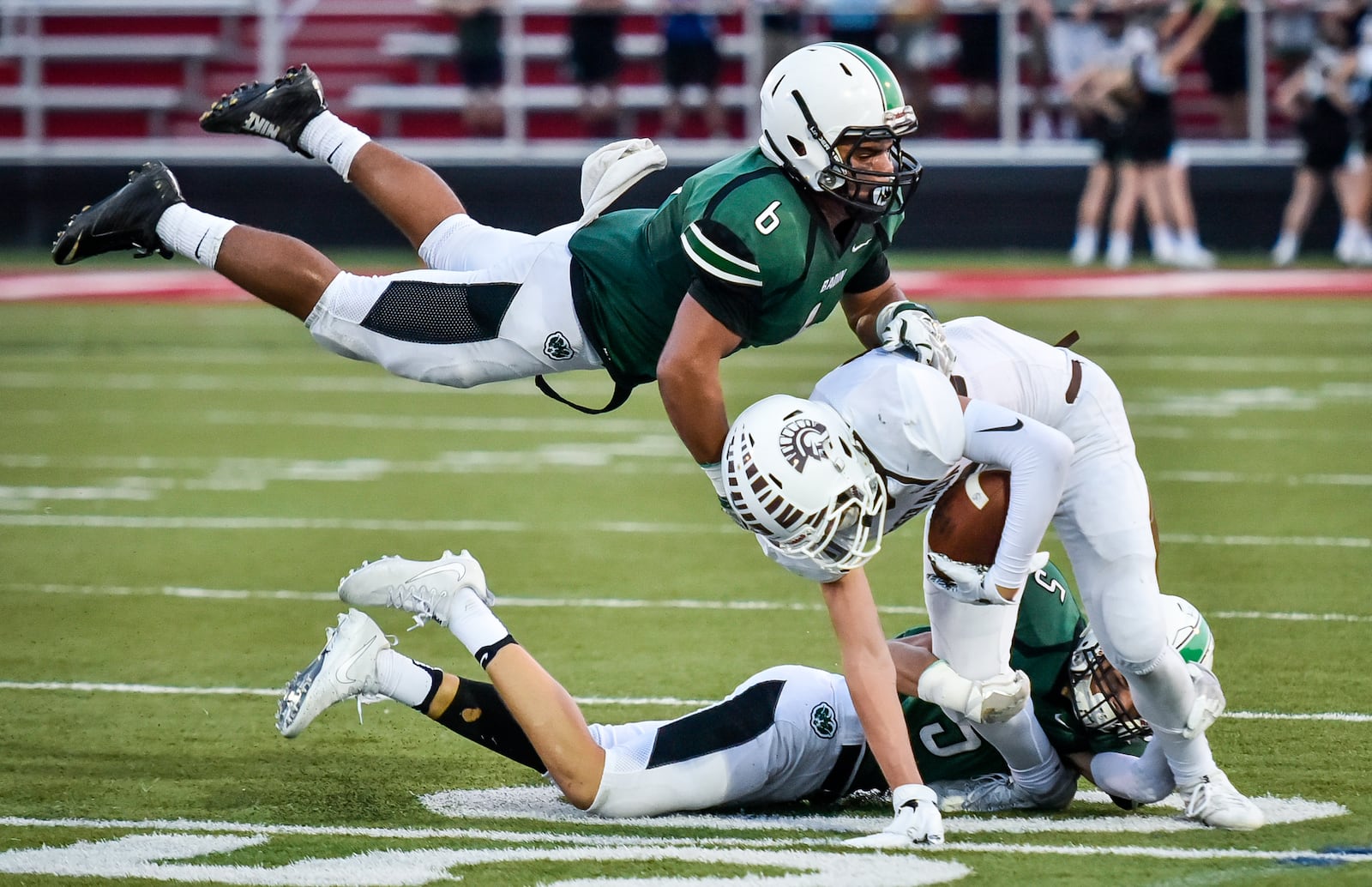 Badin’s Lavassa Martin (6) and Marshall Flaig (5) tackle Roger Bacon’s Zak Cappel during their game last Friday at Fairfield Stadium. The host Rams won 41-21. NICK GRAHAM/STAFF