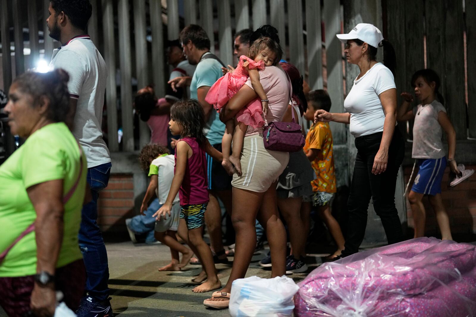 People displaced by violence in towns across the Catatumbo region, where rebels of the National Liberation Army, or ELN, have been clashing with former members of the Revolutionary Armed Forces of Colombia, arrive for shelter at a soccer stadium in Cúcuta, Colombia, Sunday, Jan. 19, 2025. (AP Photo/Fernando Vergara)