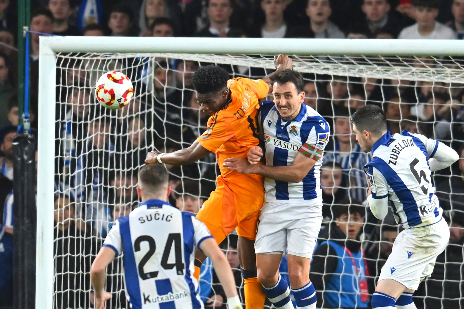 Real Sociedad's Mikel Oyarzabal, centre, challenges for the ball with Real Madrid's Aurelien Tchouameni during the Spanish Copa del Rey soccer match between Real Sociedad and Real Madrid at the Reale Arena in San Sebastian, Spain, Wednesday, Feb. 26, 2025. (AP Photo/Miguel Oses)