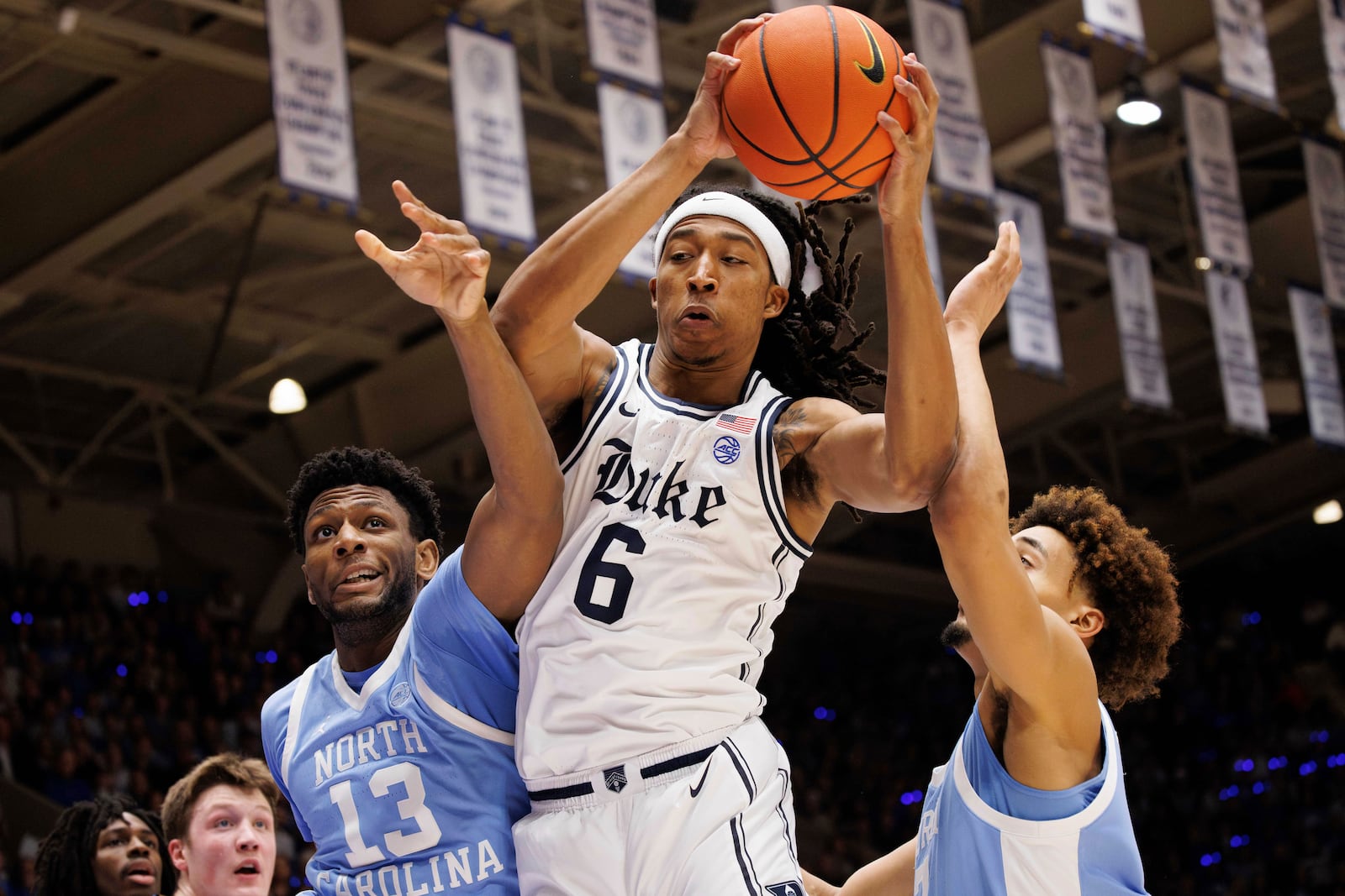 Duke's Maliq Brown (6) grabs a rebound between North Carolina's Jalen Washington (13) and Seth Trimble, right, during the first half of an NCAA college basketball game in Durham, N.C., Saturday, Feb. 1, 2025. (AP Photo/Ben McKeown)