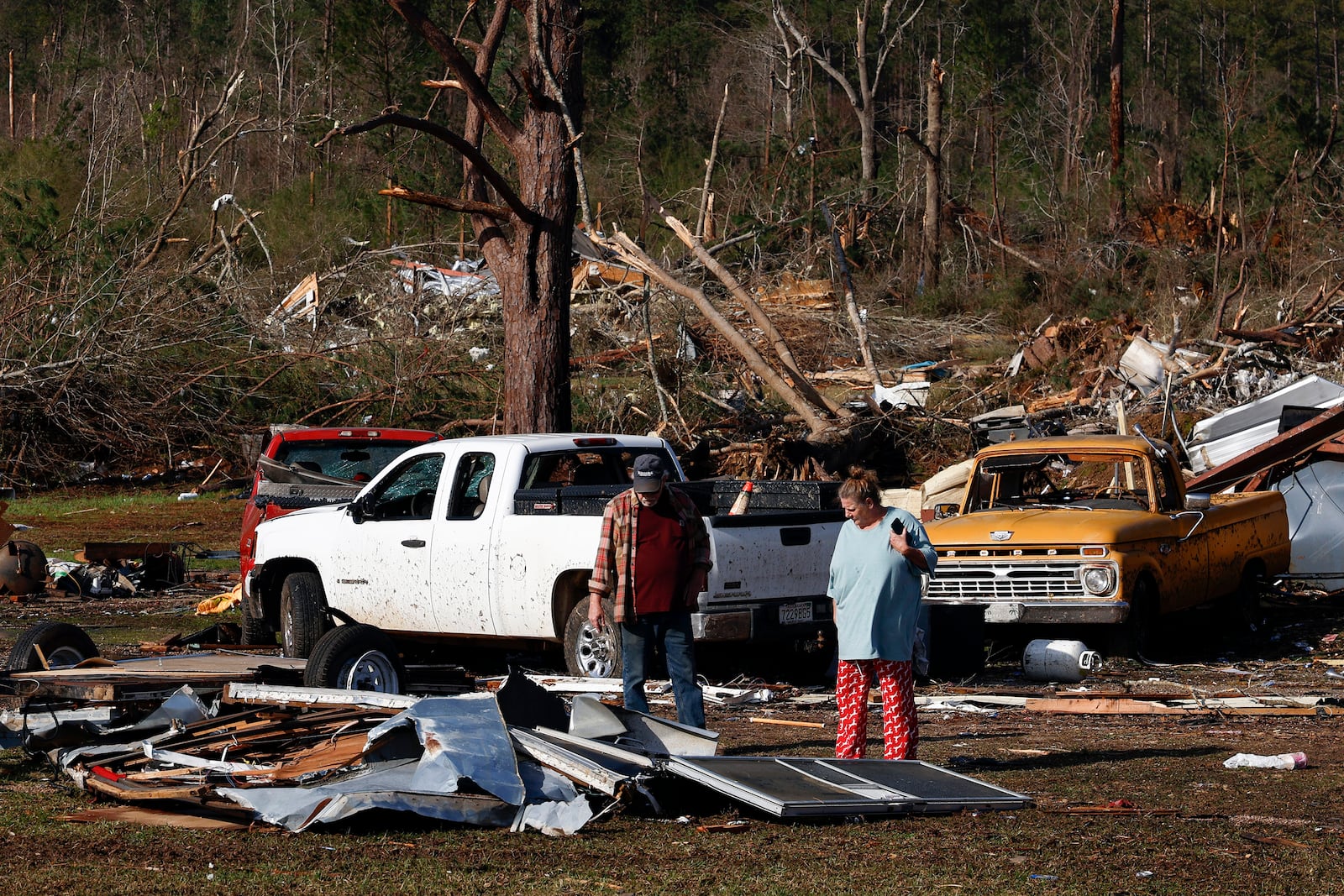 Residents look for personal belongings in the damage after a tornado passed through, Sunday, March 16, 2025, in Plantersville, Ala. (AP Photo/Butch Dill)