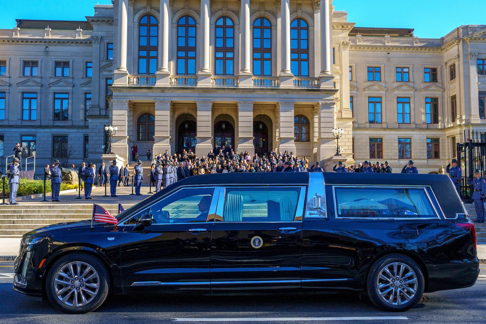 The hearse transporting the body of former President Jimmy Carter stops at Georgia's State Capitol for a moment of silence with Gov. Brian Kemp, Lt. Gov. Burt Jones, Mayor of Atlanta Andre Dickens, members of the Georgia Legislature, and Georgia State Patrol Troopers on Saturday, Jan. 4, 2025, in Atlanta. (Matthew Pearson/WABE via AP)