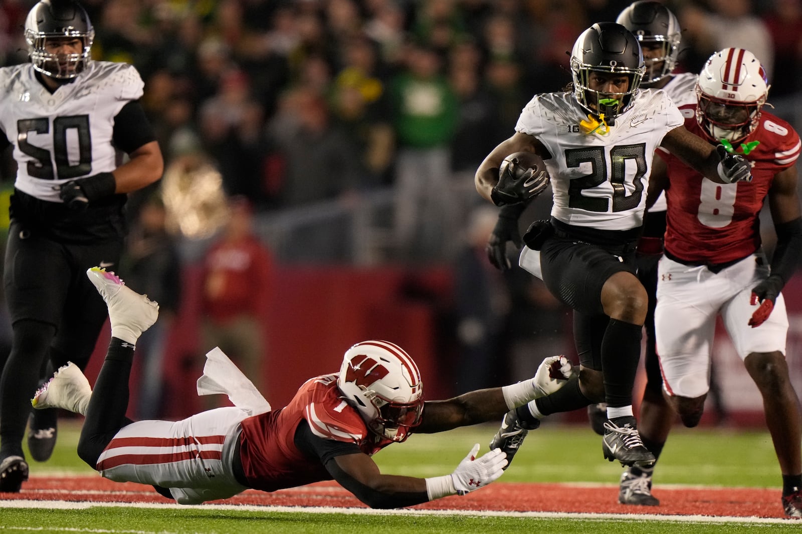 Wisconsin's Jake Chaney (1) tries to stop Oregon's Jordan James (20) during the first half of an NCAA college football game Saturday, Nov. 16, 2024, in Madison, Wis. (AP Photo/Morry Gash)