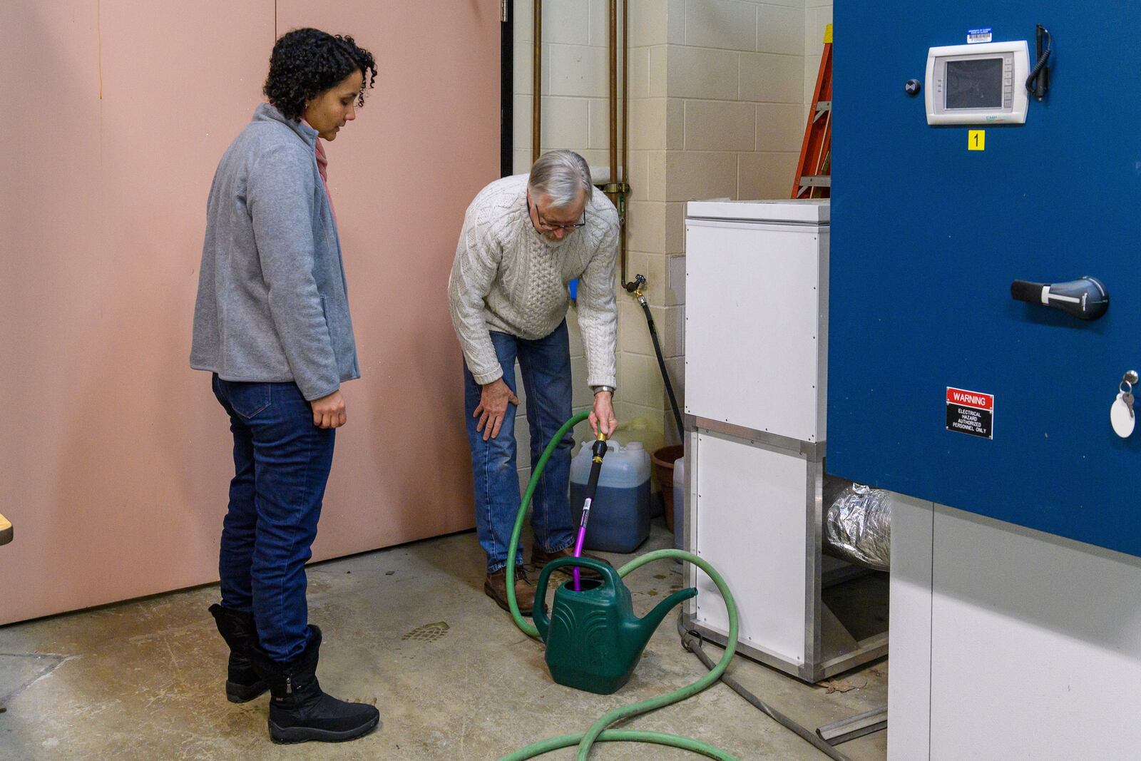 Dr. Michelle da Fonseca, left, and Dr. Brian Diers prepare to water test plants in the growing chamber at the Soybean Innovation Lab, Thursday, Feb. 13, 2025, in Champaign, Ill. (AP Photo/Craig Pessman)