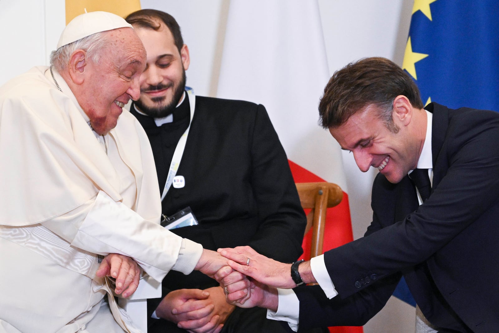 Pope Francis shakes hands with French President Emmanuel Macron in Ajaccio at the end of his one-day visit in the French island of Corsica, Sunday, Dec. 15, 2024. (Tiziana Fabi, Pool Via AP)