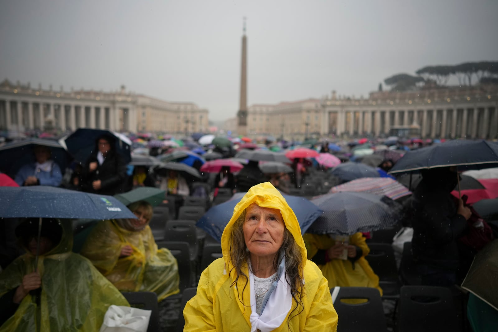 A participant in a mass for the jubilar pilgrims from Naples waits for the start of the celebration under pouring rain in St. Peter's Square at The Vatican, Saturday, March 22, 2025. (AP Photo/Andrew Medichini)