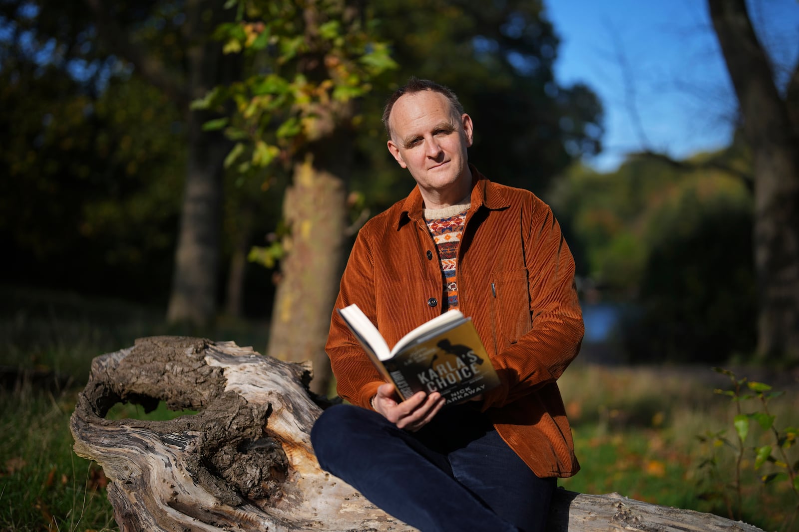 British author Nick Harkaway, son of John le Carre, poses for a photograph a copy of his book, during an interview with The Associated Press, at his home, in London, Thursday, Oct. 24, 2024. (AP Photo/Kin Cheung)