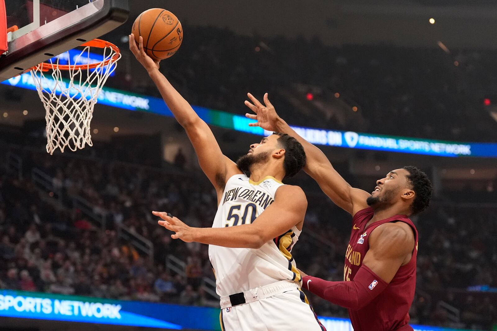 New Orleans Pelicans forward Jeremiah Robinson-Earl (50) goes to the basket in front of Cleveland Cavaliers guard Donovan Mitchell, right, in the first half of an NBA basketball game, Wednesday, Nov. 20, 2024, in Cleveland. (AP Photo/Sue Ogrocki)