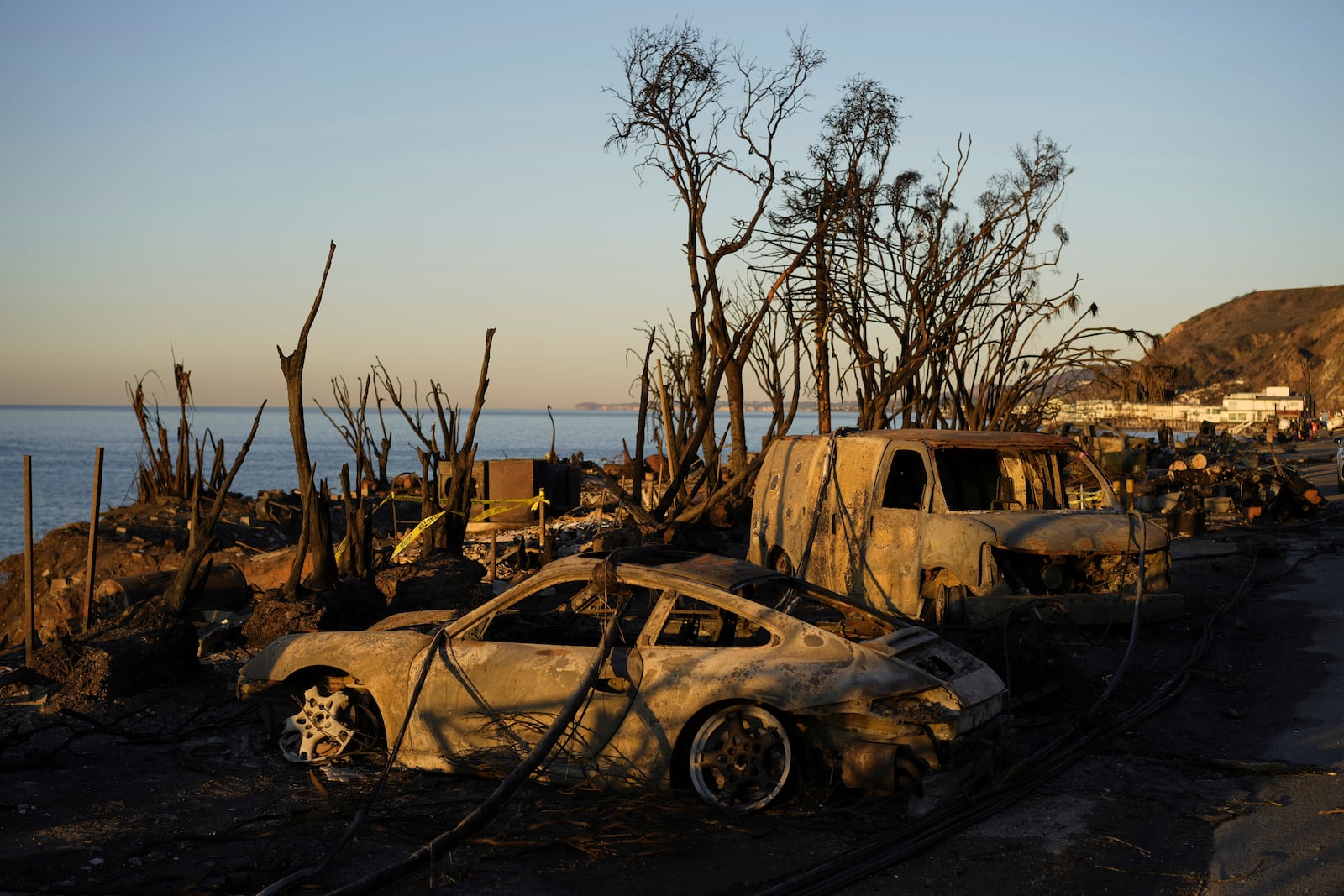 Charred vehicles sit along the Pacific Coast Highway, Tuesday, Jan. 14, 2025, in Malibu, Calif. (AP Photo/Carolyn Kaster)