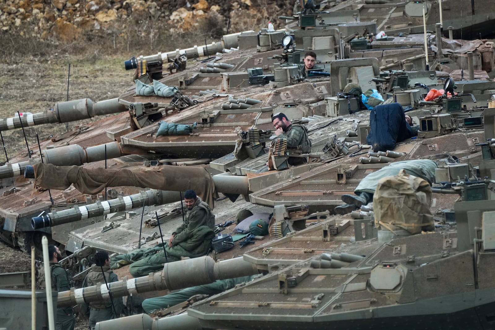 Israeli soldiers work on tanks in a staging area in northern Israel near the Israel-Lebanon border, Tuesday, Oct. 1, 2024. (AP Photo/Baz Ratner)