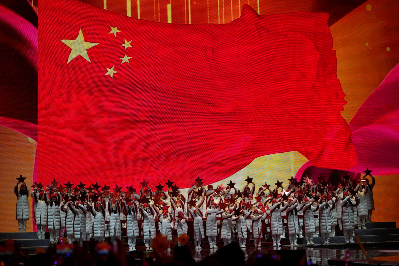 Performers prepare to ring in the new year near a Chinese national flag during a count down event held in Beijing, Tuesday, Dec. 31, 2024. (AP Photo/Ng Han Guan)