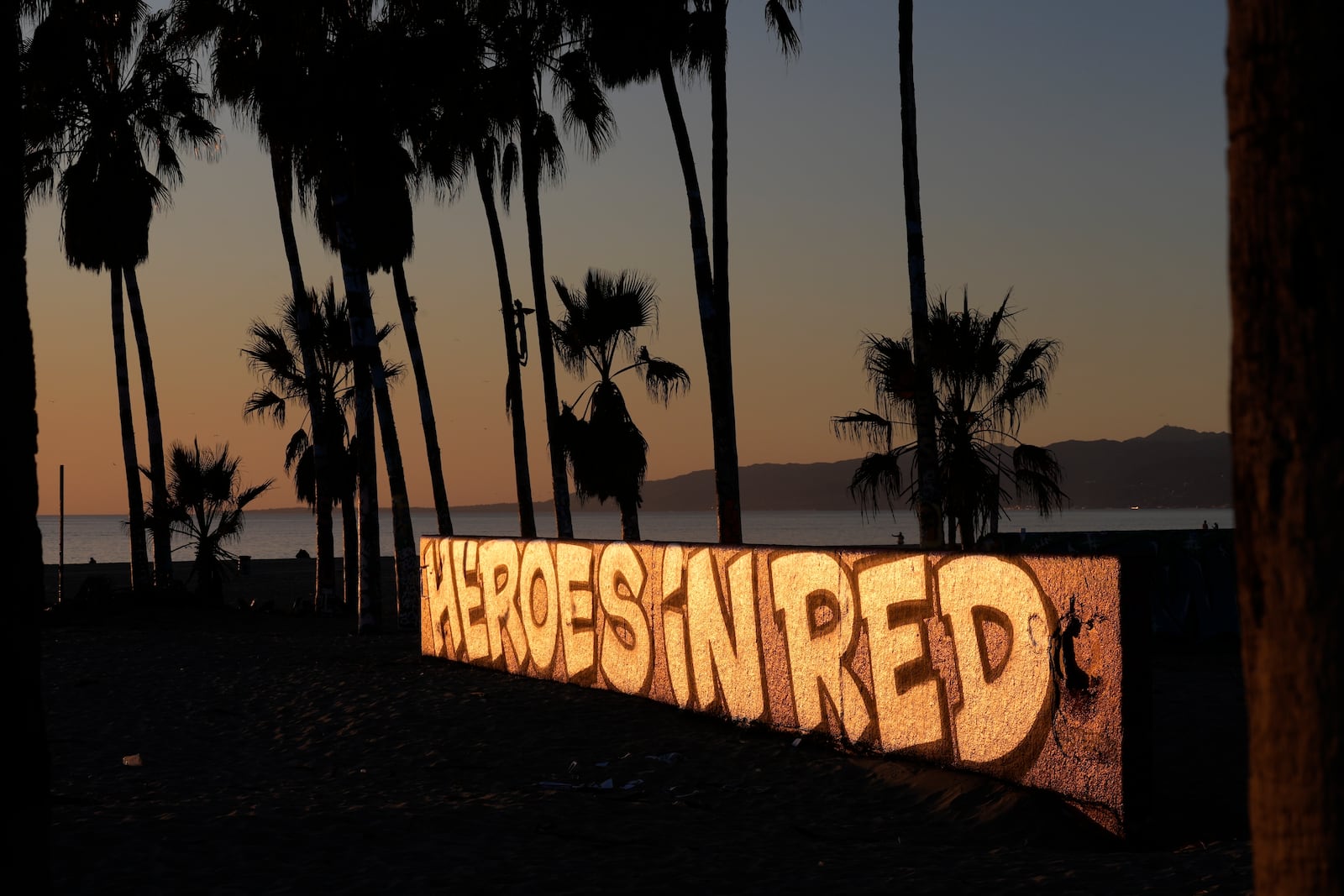 A mural by Sergei Statsenko, who also goes by the artist name Steeke, thanks firefighters in the Venice Beach area of Los Angeles as wildfires burn Monday, Jan. 13, 2025. (AP Photo/Damian Dovarganes)