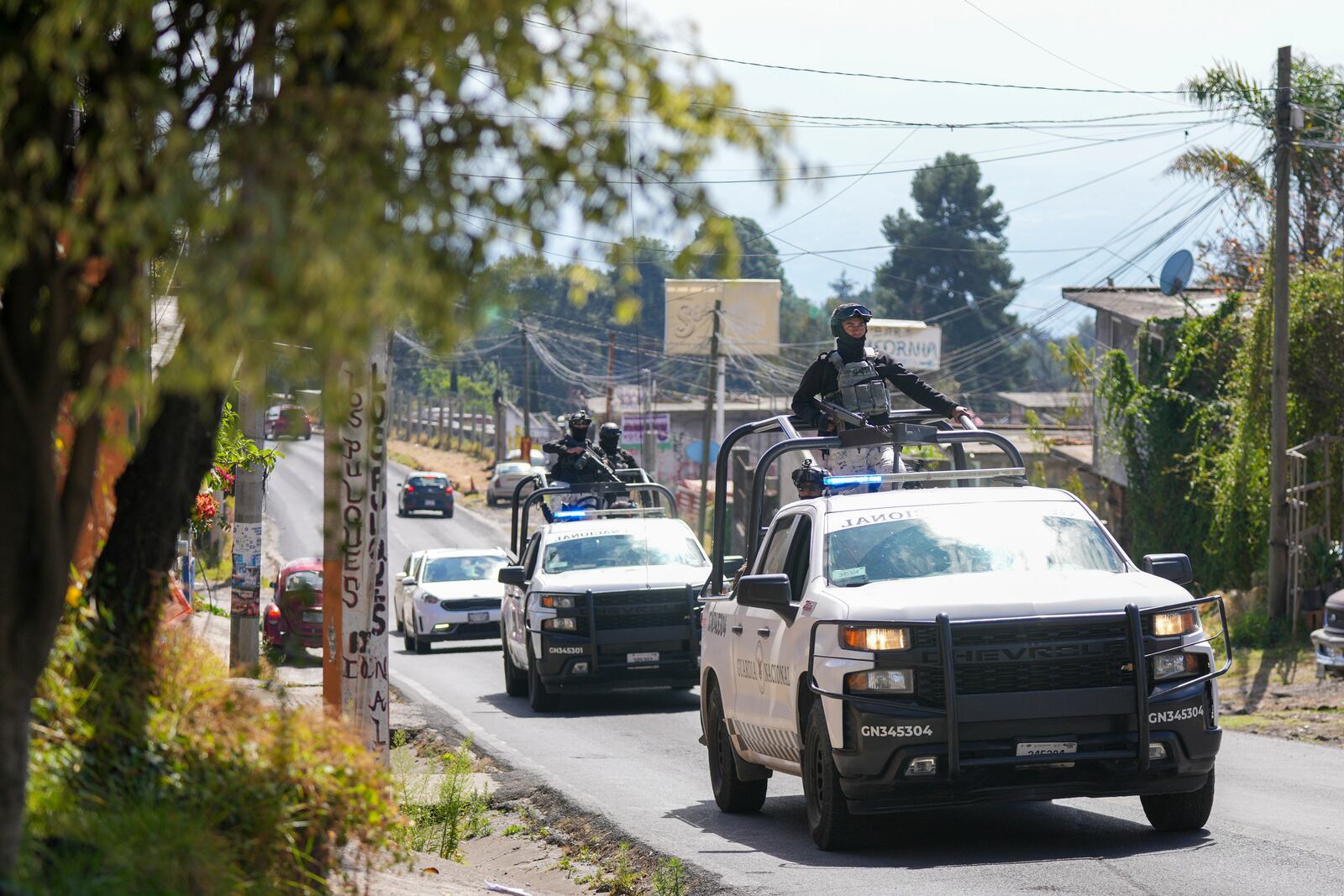 Members of Mexico's National Guard patrol the streets where five people were killed the day before, in Huitzilac, Mexico, Tuesday, Jan. 14, 2025. (AP Photo/Fernando Llano)