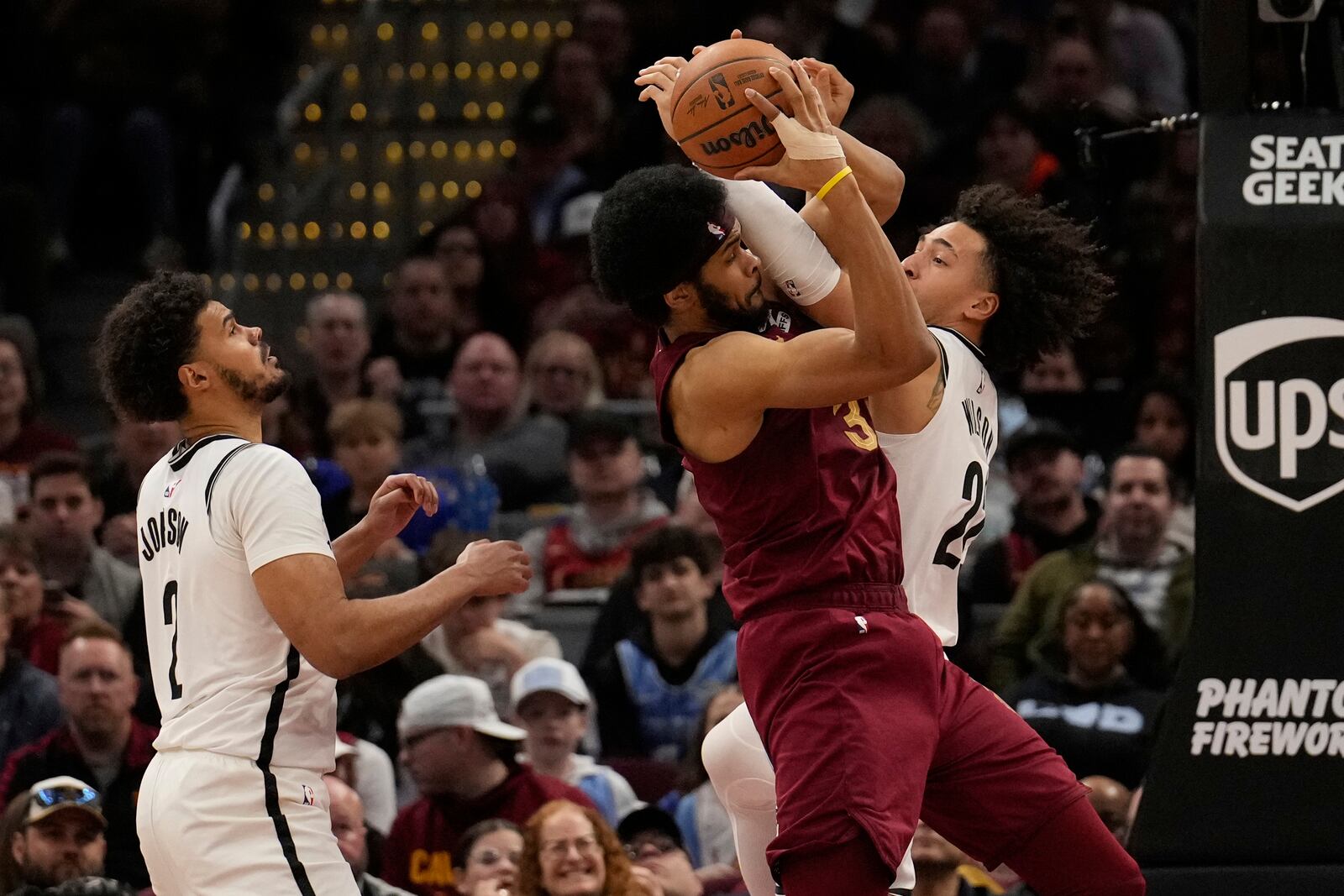 Brooklyn Nets forward Jalen Wilson, right, fouls Cleveland Cavaliers center Jarrett Allen, center, as forward Cameron Johnson (2) looks on in the second half of an NBA basketball game, Tuesday, March 11, 2025, in Cleveland. (AP Photo/Sue Ogrocki)