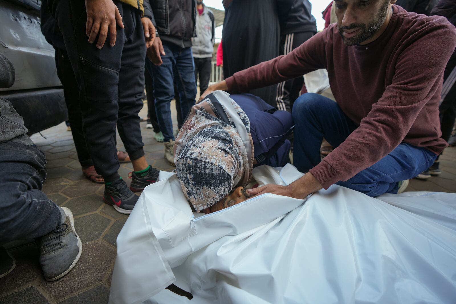 Sahar Mohannamourns over the body of her brother, victim of an Israeli army strike on the Nuseirat refugee camp, at the Al-Aqsa Martyrs hospital in Deir al-Balah, Gaza Strip, Thursday Dec. 12, 2024. Palestinian medical officials say Israeli airstrikes have killed at least 28 people in the Gaza Strip, including seven childr en and a woman. (AP Photo/Abdel Kareem Hana)