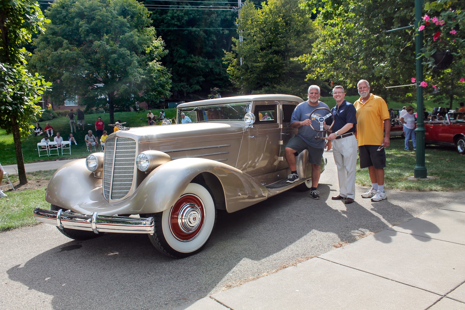 Greg Ornazian's beautiful gold 1929 Duesenberg J Bohman & Schwartz sedan was awarded the R. H. Grant Best of Show Award presented by AAA. From left, Greg Ornazian, Thomas Vaughn, AAA Regional President and Paul Rich, the creator of the award.  Photo by Haylie Schlater