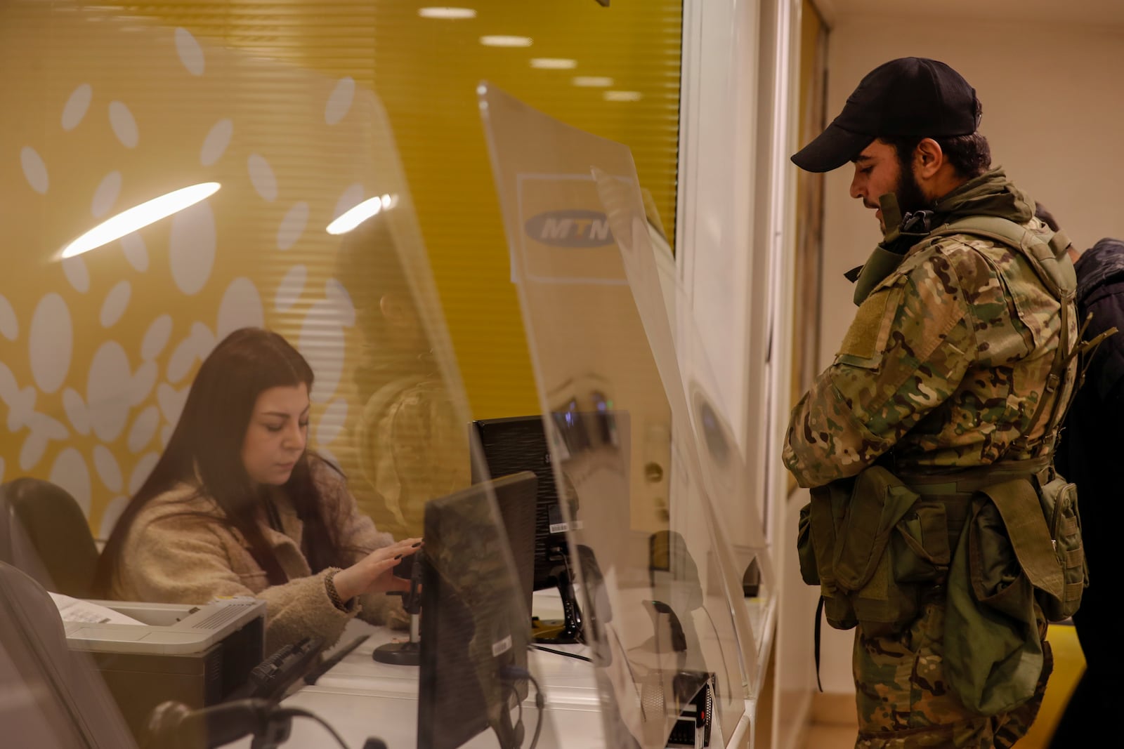 A Syrian opposition fighter waits to charge his mobile phone in Damascus, Syria, Tuesday, Dec. 10, 2024. (AP Photo/Omar Sanadiki)