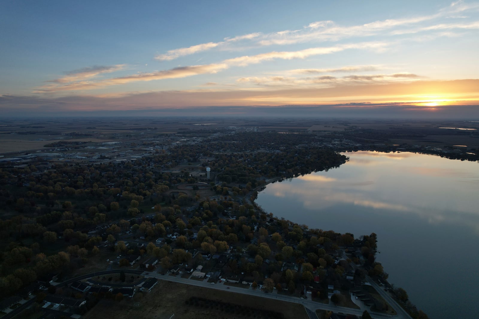 The sun rises over Okabena Lake and the town of Worthington, Minn., on Tuesday, Oct. 22, 2024. (AP Photo/Jessie Wardarski)