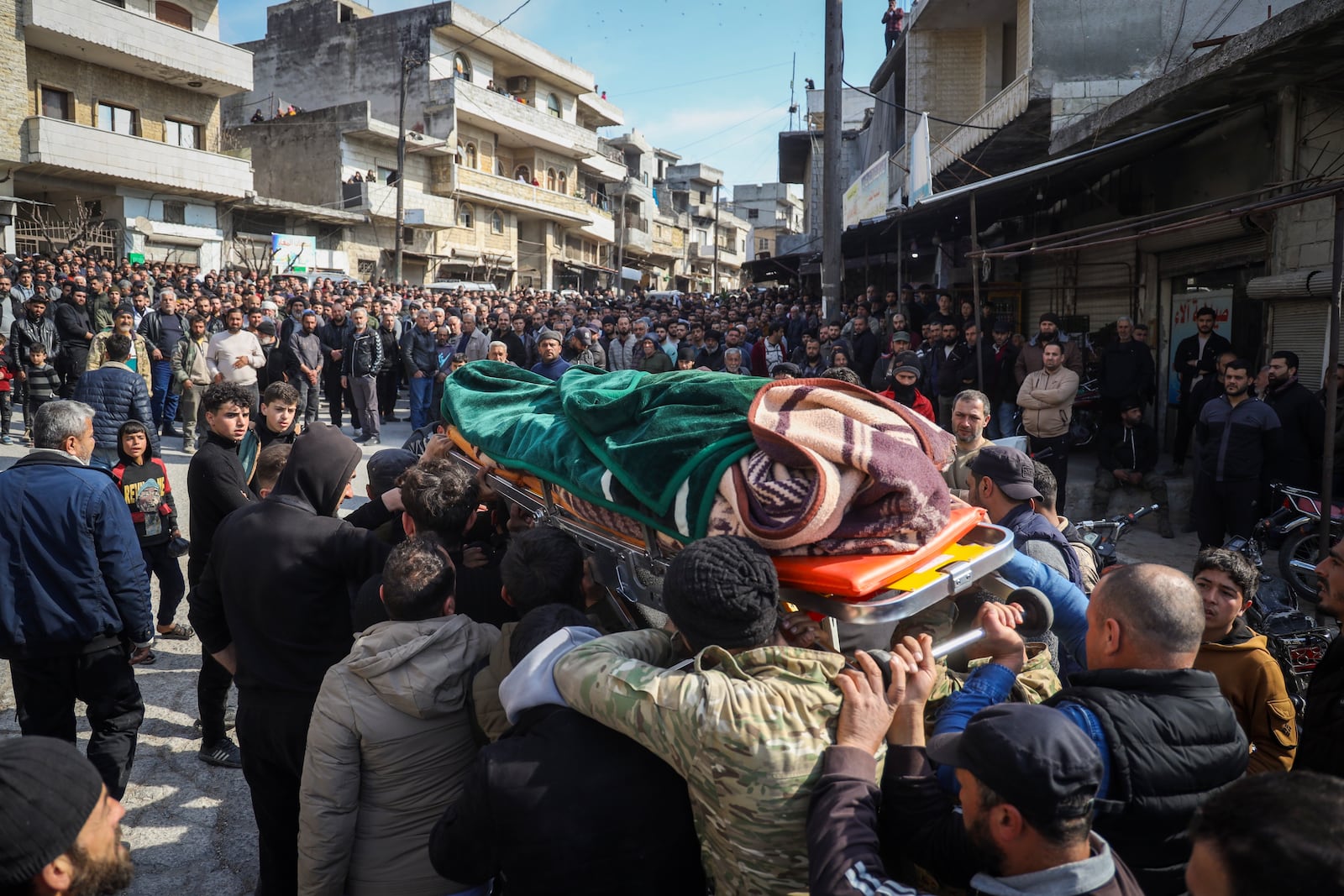 Relatives and neighbours attend funeral procession for four Syrian security force members killed in clashes with loyalists of ousted President Bashar Assad in coastal Syria, in the village of Al-Janoudiya, west of Idlib, Saturday, March 8, 2025. (AP Photo/Omar Albam)