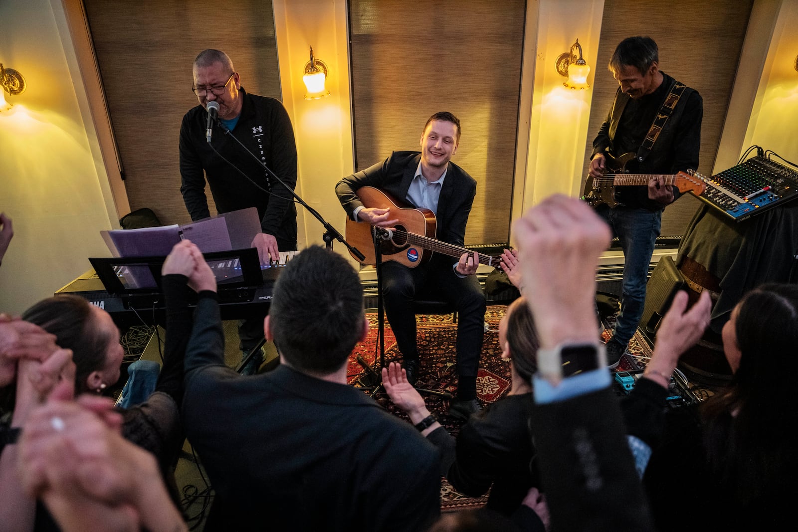 Chairman of Demokraatit, Jens-Frederik Nielsen, center, plays guitar as he reacts during the election party at Demokraatit by cafe Killut in Nuuk, early Wednesday, March 12, 2025. (Mads Claus Rasmussen/Ritzau Scanpix via AP)