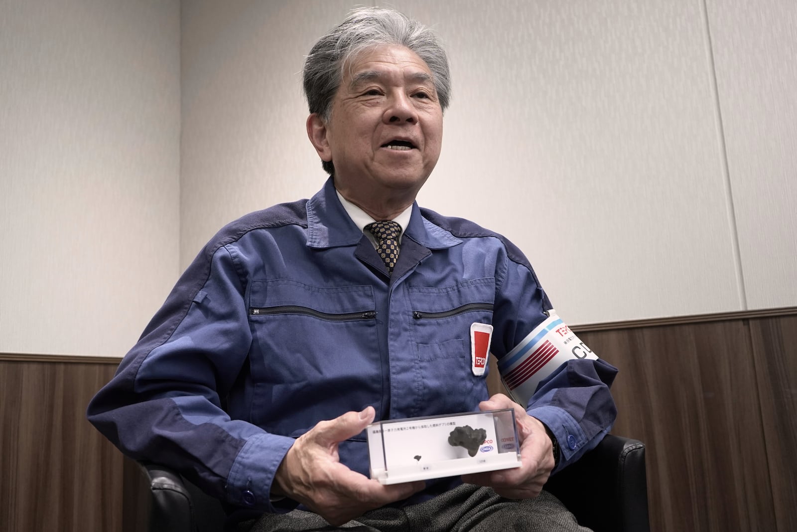 Akira Ono, chief decommissioning officer at the Tokyo Electric Power Company Holdings (TEPCO) holds model of nuclear fuel debris which was extracted from the damaged Fukushima Daiichi nuclear power plant last year, during an interview with the Associated Press Wednesday, March 5, 2025, in Tokyo. (AP Photo/Mayuko Ono)