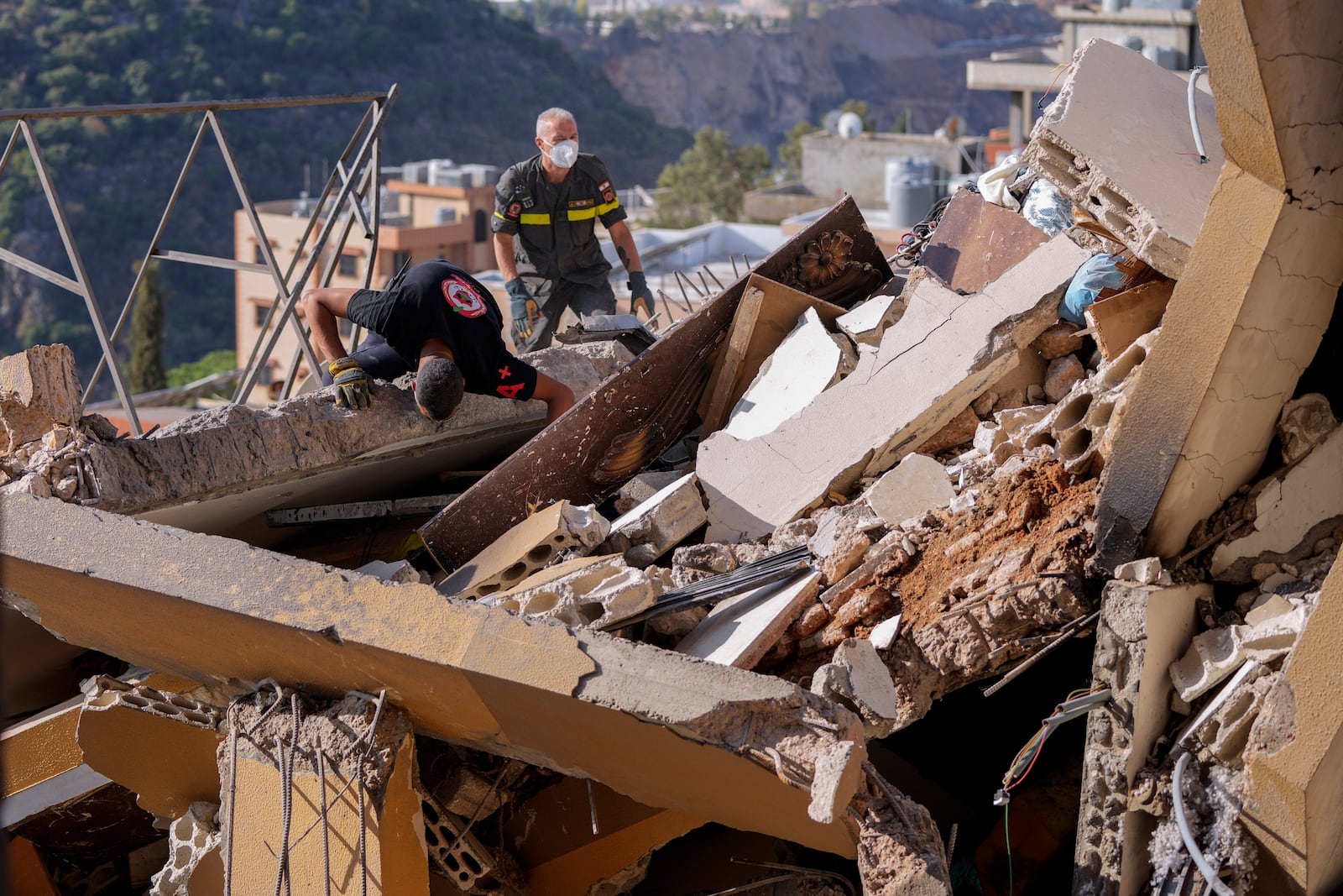 Rescue workers search for victims in the rubble of a destroyed building hit in an Israeli airstrike on Tuesday night, in Barja, Lebanon, Wednesday, Nov. 6, 2024. (AP Photo/Hassan Ammar)