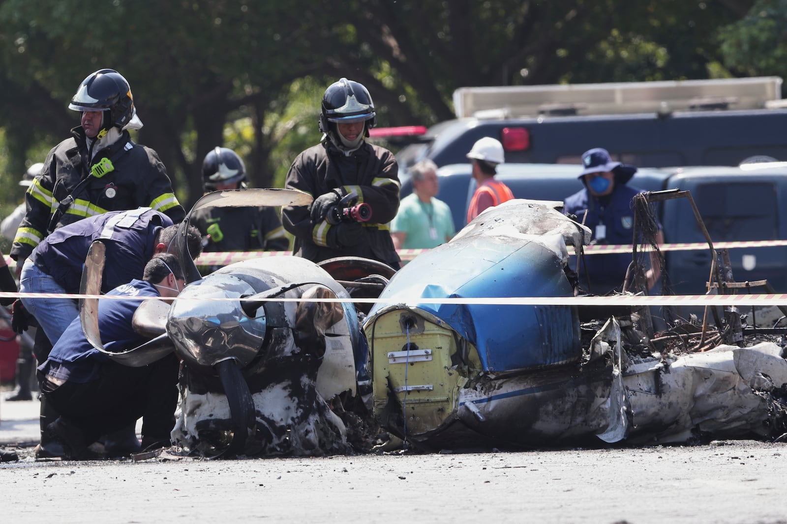 Firefighters inspect a small aircraft that crashed on an avenue in Sao Paulo, Friday, Feb. 7, 2025. (AP Photo/Ettore Chiereguini)