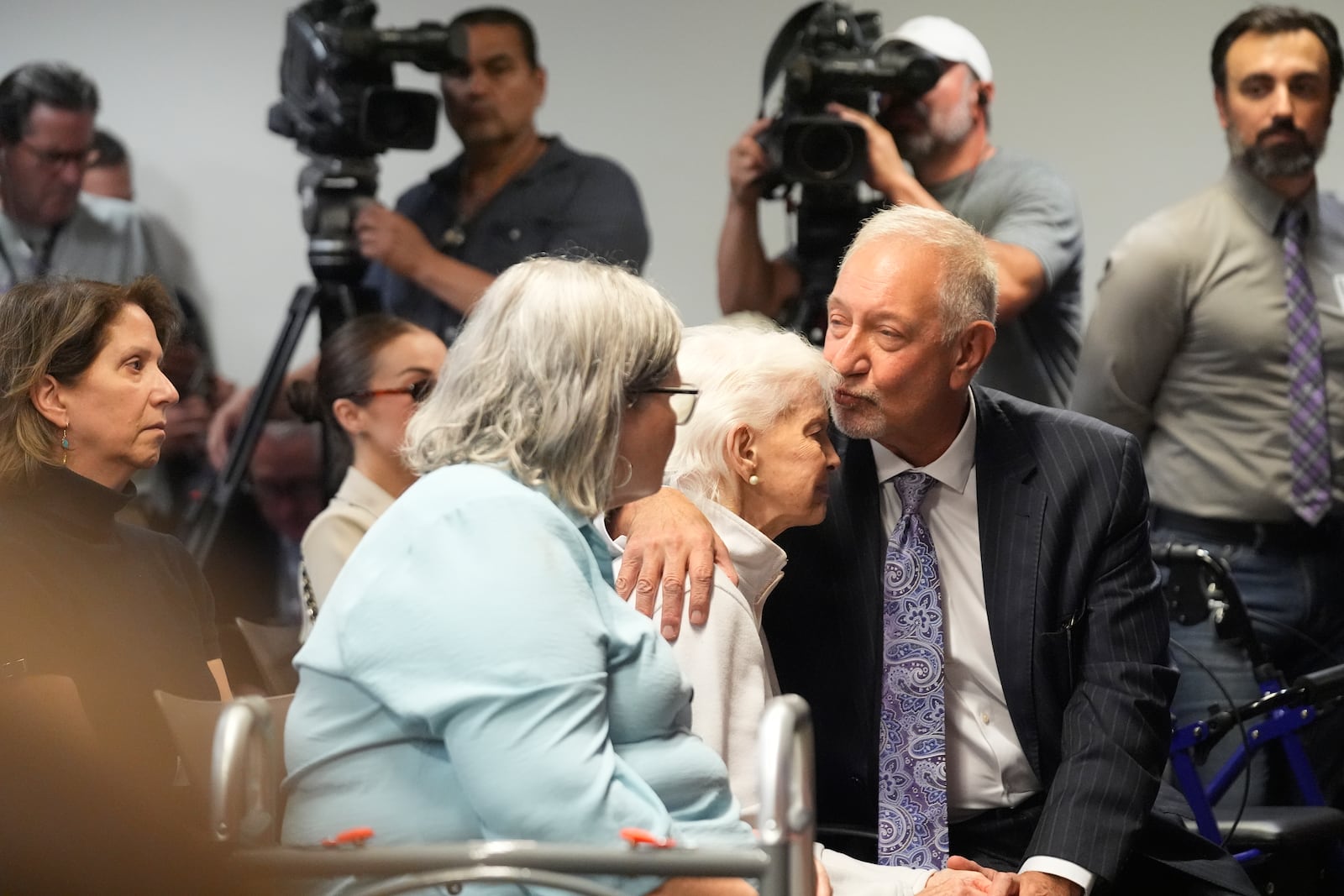 Kitty Menendez's sister, Joan Andersen VanderMolen, center, is greeted by Defense Attorney Mark Geragos, right, as Diane Hernandez niece of Kitty Menendez, left, looks on prior to a news conference being held by Los Angeles County District Attorney George Gascon at the Hall of Justice on Thursday, Oct. 24, 2024, in Los Angeles (AP Photo/Damian Dovarganes)