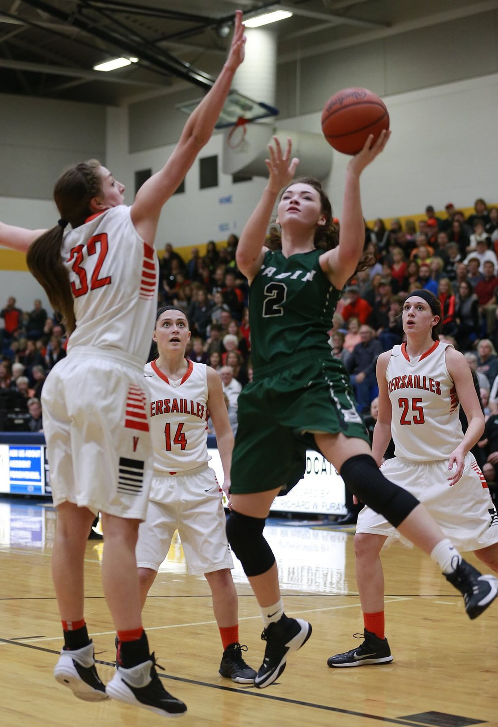 Badin’s Shelby Nusbaum puts up a shot under pressure from Versailles’ Danielle Winner during Wednesday’s Division III regional semifinal at Springfield. BILL LACKEY/STAFF