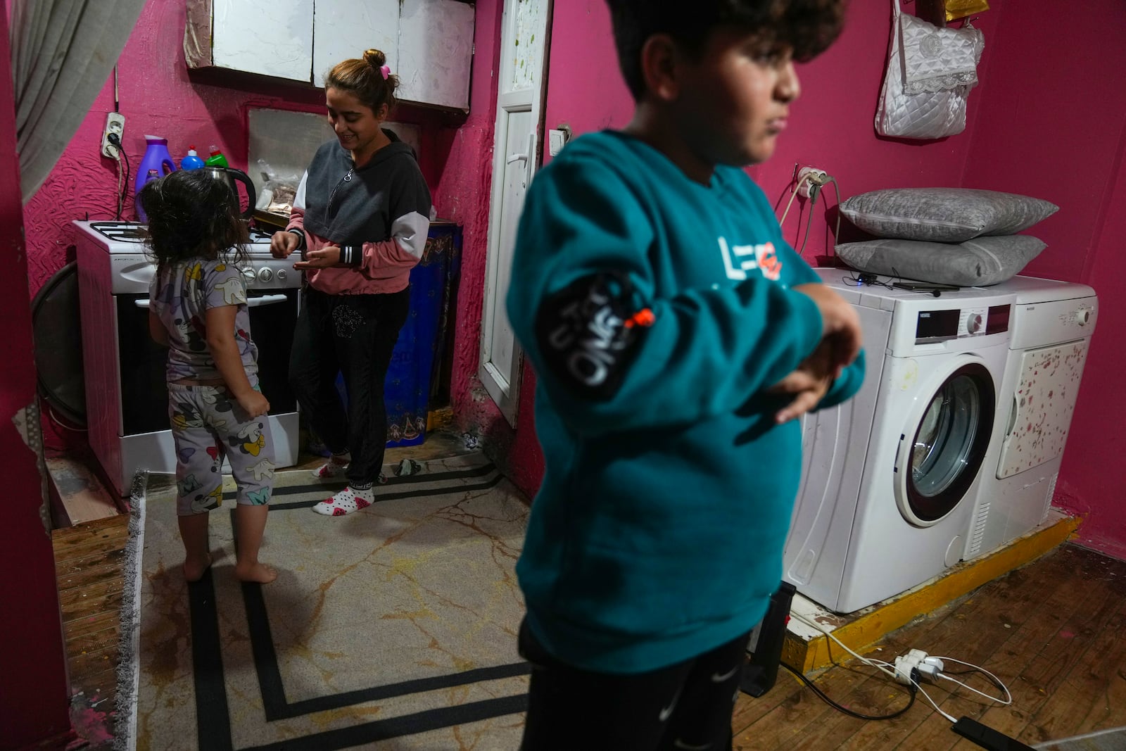 Rukiye Sahin, 28, talks to her daughter Dilan, 5, near her son Atakan, 11, in the family's one-room apartment in the Tarlabasi neighborhood in Istanbul, Turkey, Wednesday, Dec. 4, 2024. (AP Photo/Francisco Seco)