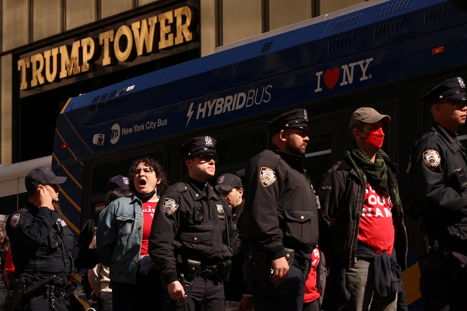 Demonstrators from the group, Jewish Voice for Peace, who were arrested while protesting inside Trump Tower, wait to board a bus escorted by New York Police officers, Thursday, March 13, 2025, in New York. (AP Photo/Yuki Iwamura)