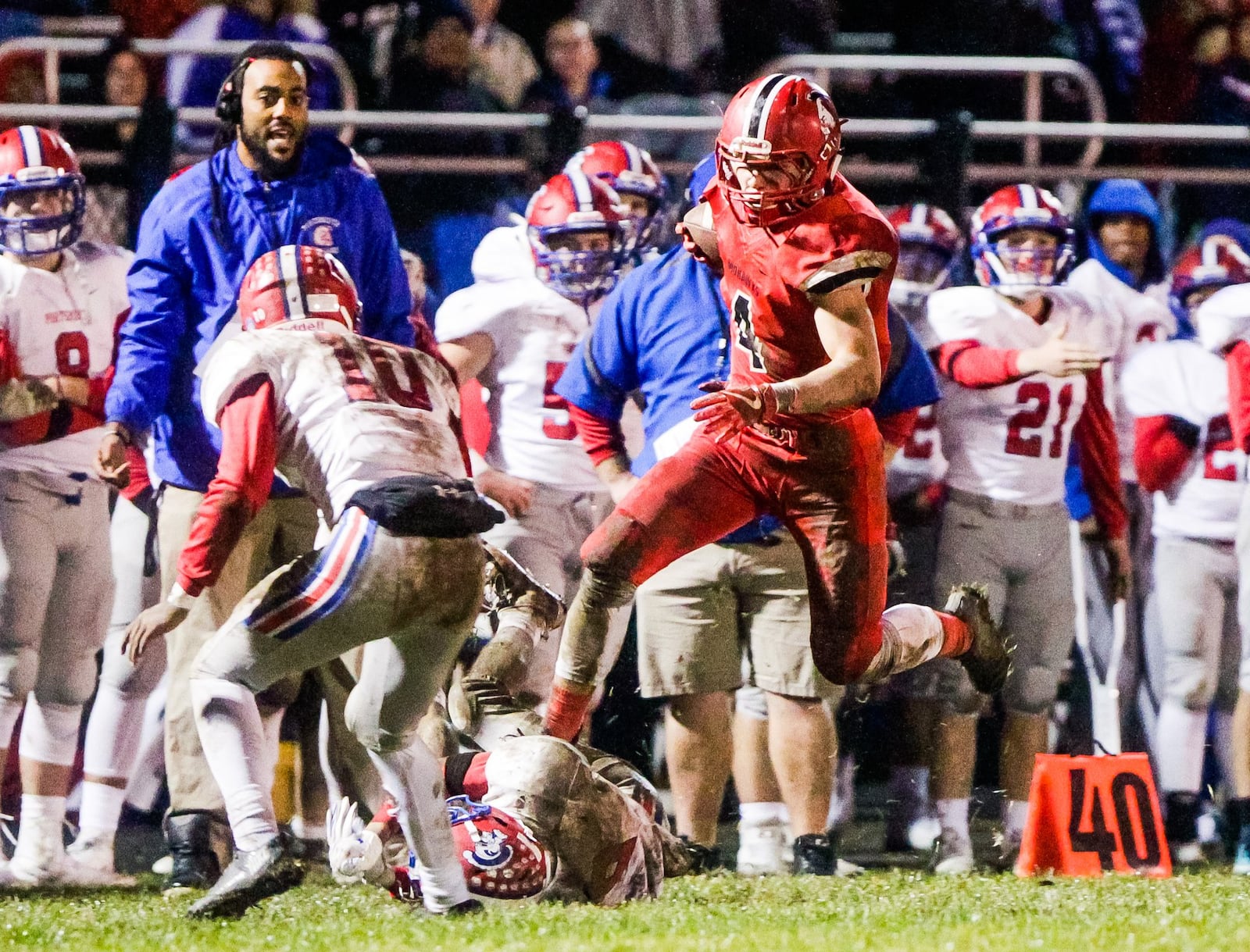 Madison’s Devin Oligee jumps over his opponent after getting an interception during Saturday night’s 26-0 win over Portsmouth in a Division V, Region 20 playoff game at Brandenburg Field in Madison Township. NICK GRAHAM/STAFF