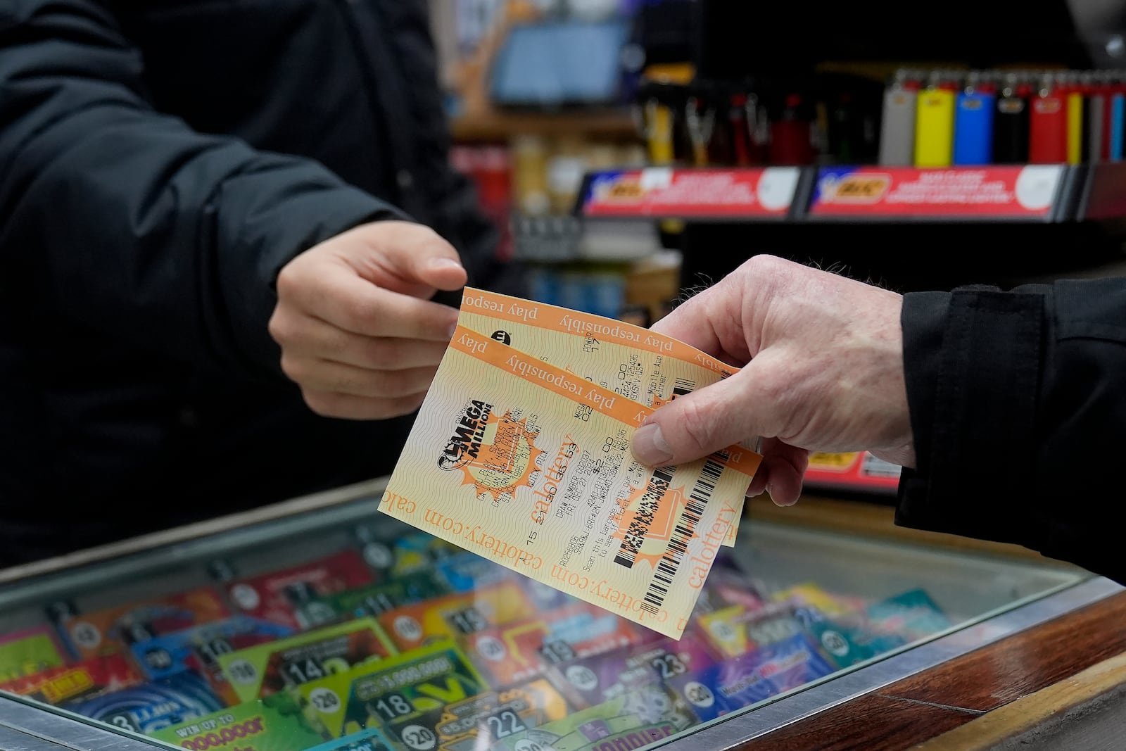 Rob, right, buys a Mega Millions ticket at Rossi's Deli in San Francisco, Thursday, Dec. 26, 2024. (AP Photo/Jeff Chiu)