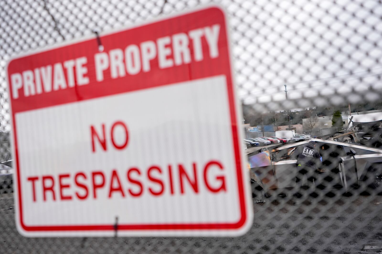 A sign hangs at the Tesla lot where Tesla Cybertrucks burned in Seattle, Monday, March 10, 2025. (AP Photo/Lindsey Wasson)