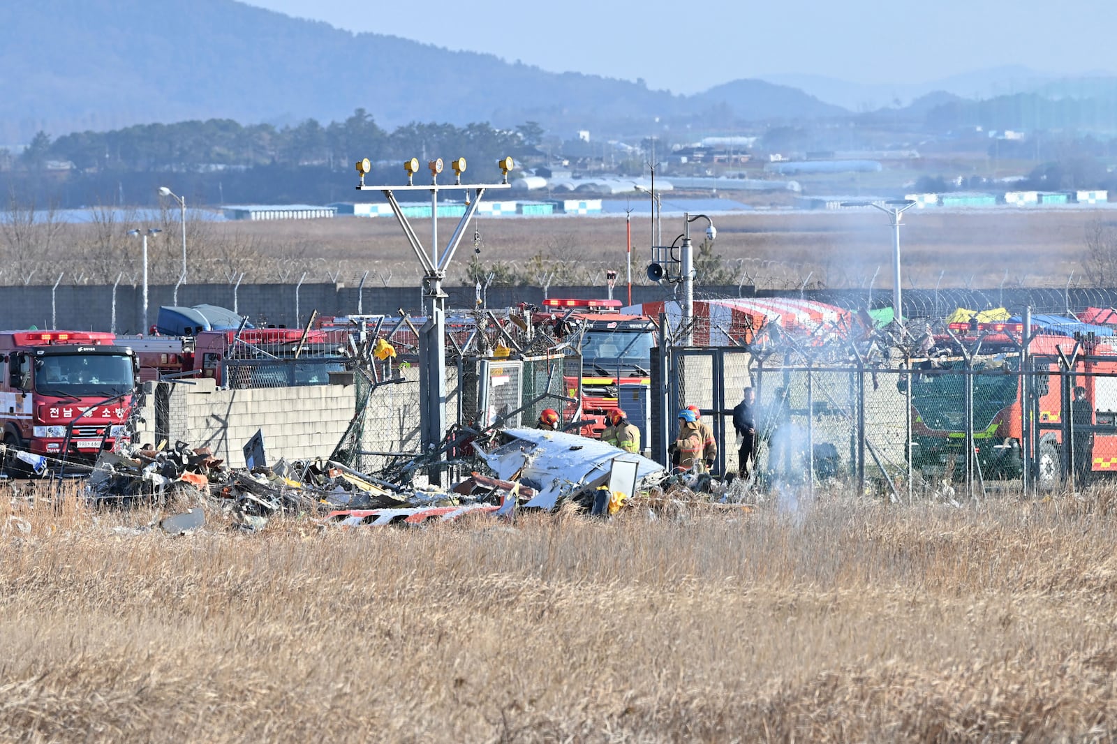 Firefighters and rescue team members work at Muan International Airport in Muan, South Korea, Sunday, Dec. 29, 2024. (Lee Young-ju/Newsis via AP)