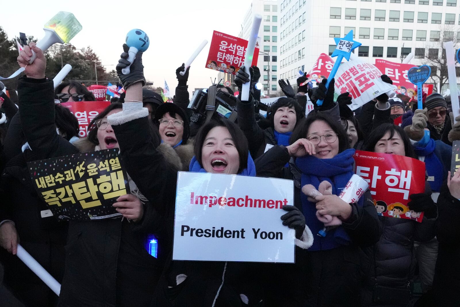 Participants react after hearing the news that South Korea's parliament voted to impeach President Yoon Suk Yeol outside the National Assembly in Seoul, South Korea, Saturday, Dec. 14, 2024. (AP Photo/Lee Jin-man)