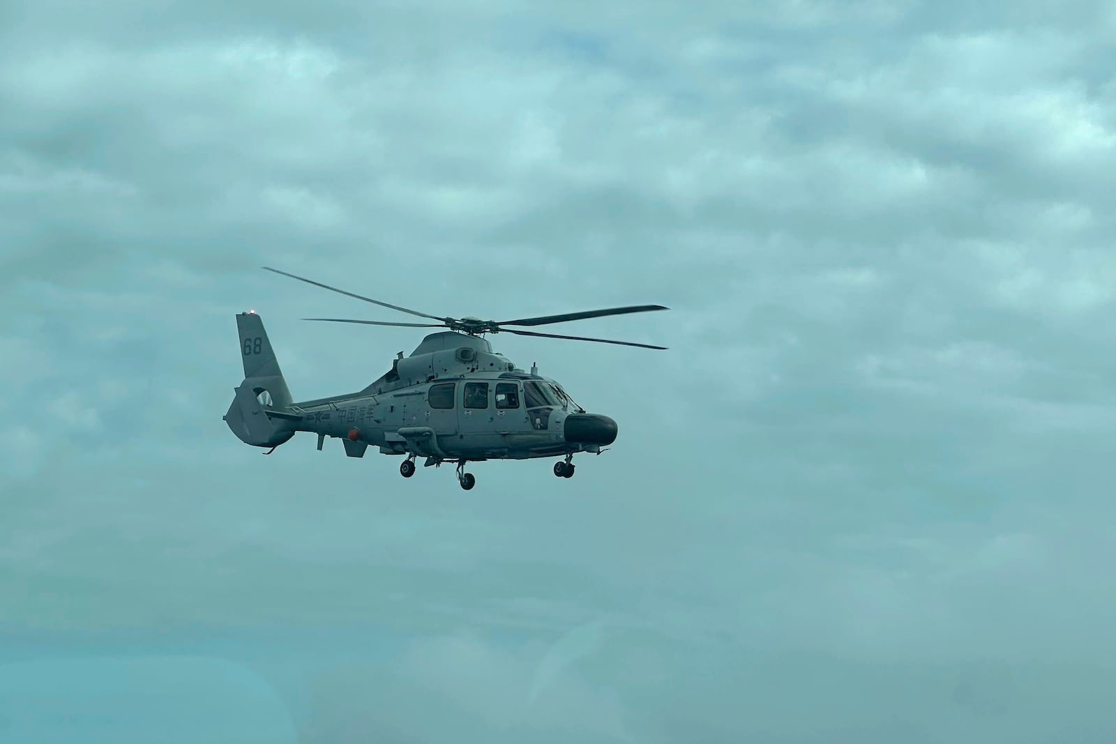 A Chinese military helicopter flies close to a Philippine Bureau of Fisheries and Aquatic (BFAR) aircraft above Scarborough shoal on Tuesday, Feb. 18, 2025. (AP Photo/Joeal Calupitan)