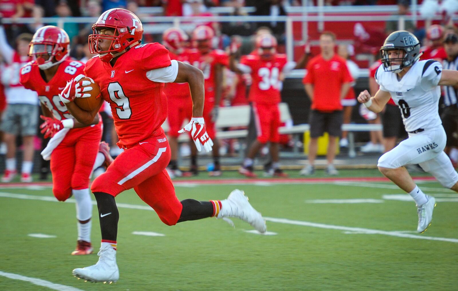 Fairfield’s Jutahn McClain (9) gets an escort from teammate Hajiere Pitts (89) en route to a touchdown Friday night’s game against Lakota East at Fairfield Stadium. NICK GRAHAM/STAFF