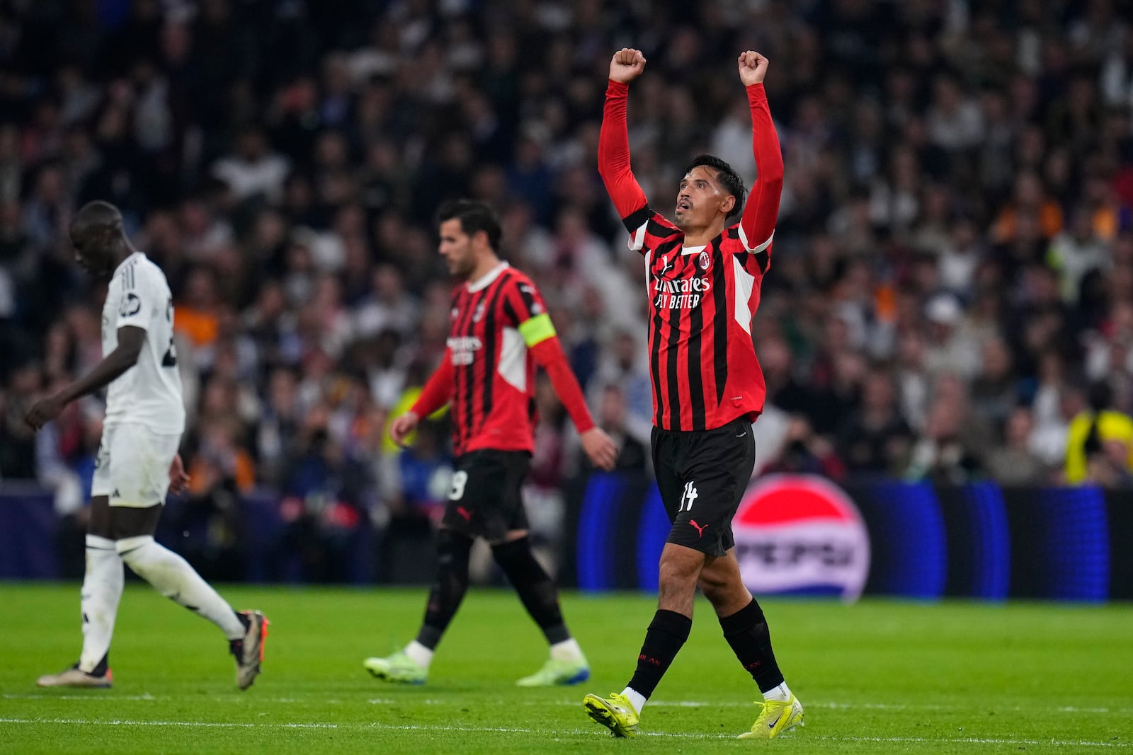 AC Milan's Tijjani Reijnders, right, celebrates after scoring his side's 3rd goal against Real Madrid during the Champions League opening phase soccer match at the Santiago Bernabeu stadium in Madrid, Spain, Tuesday, Nov. 5, 2024. (AP Photo/Manu Fernandez)