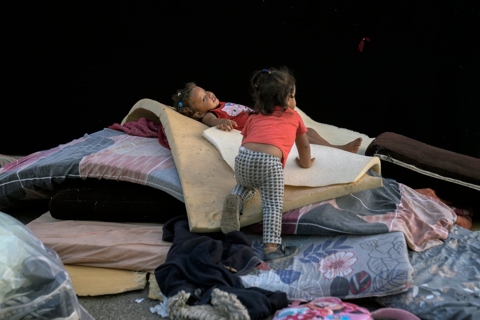 Children play next to their family's tent after fleeing the Israeli airstrikes in Dahiyeh, Beirut, Lebanon, Monday, Oct. 14, 2024. (AP Photo/Bilal Hussein)