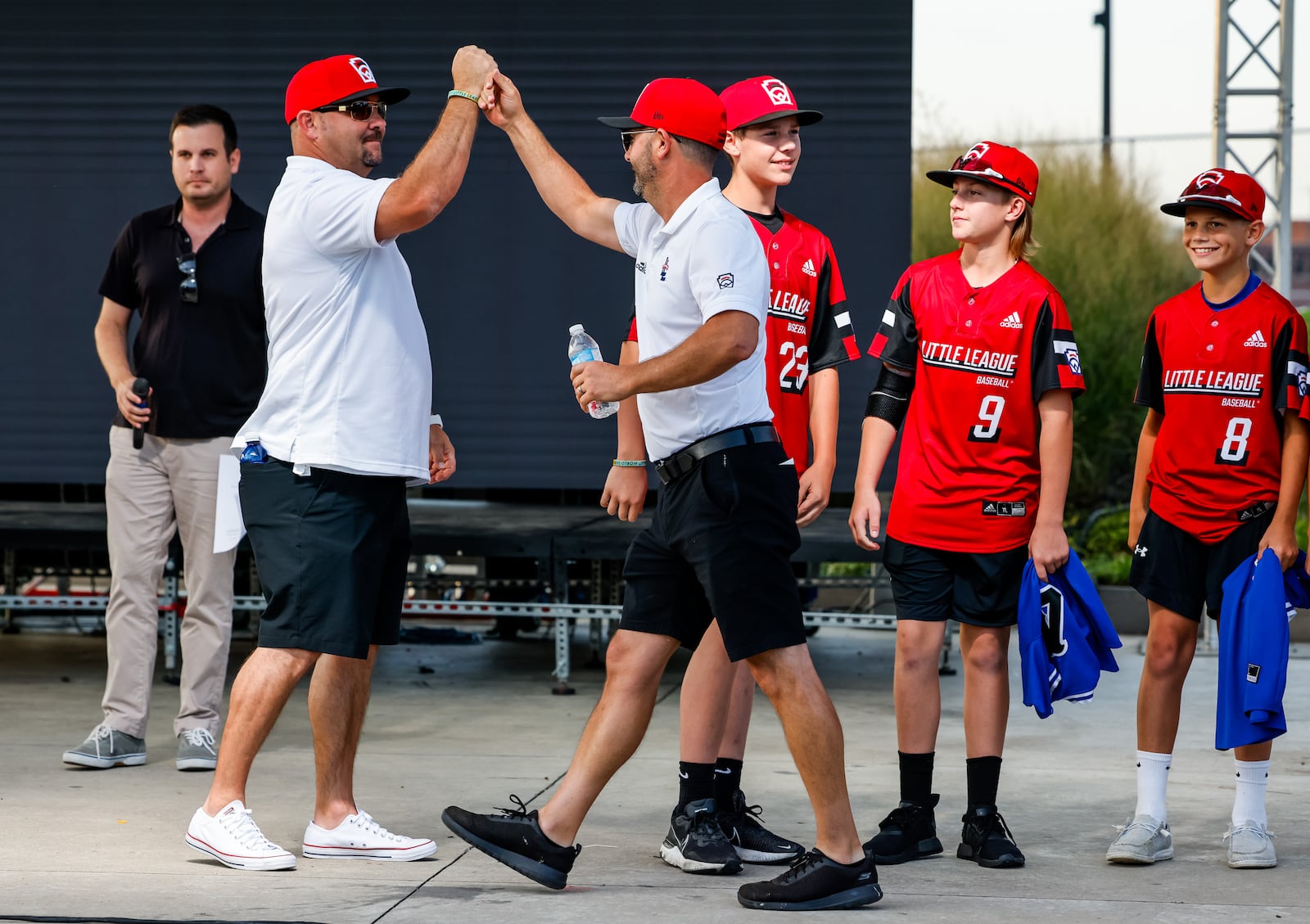 Manager Ken Coomer, right, celebrates with coach Chris  Craft as the West Side Little League All-Stars were honored for their performance in the Little League World Series with a parade and ceremony on the stage at RiversEdge Amphitheater Thursday, Sept. 2, 2021 in Hamilton. NICK GRAHAM / STAFF